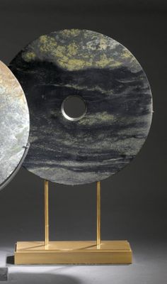 two pieces of art that are sitting on a stand