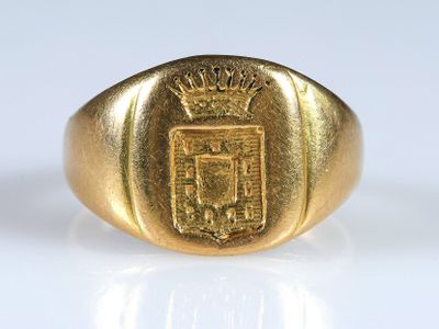 un gros plan d'une bague en or ornée d'un blason