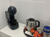 une cafetière posée sur une étagère blanche, à côté d'une cafetière