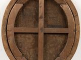a wooden circular window on the wall of a building