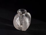 a clear glass vase sitting on a black surface