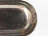a silver tray with a handle on a white surface