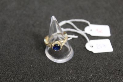 une bague sertie d'une pierre bleue, posée sur une table