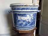 un grand vase bleu et blanc posé sur un socle en bois