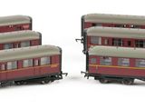 two red and white train cars sitting next to each other on a white surface