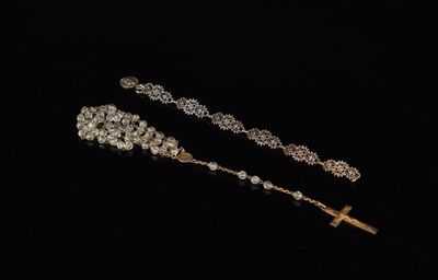 un gros plan d'un chapelet et d'une croix sur fond noir