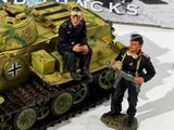 two figurines of men sitting on top of a tank