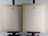 pair of wooden easels with two empty canvass on them