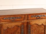 a wooden cabinet with a marble top on a wooden floor