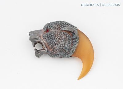 a brooch of a lion head with a horn on it