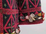 an image of a woman ' s jacket with brooches on it