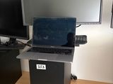 un ordinateur portable posé sur un socle noir