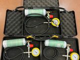trois compresseurs d'air dans une mallette, avec tuyaux et manomètres