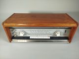 an old radio sitting on top of a wooden table next to a white wall