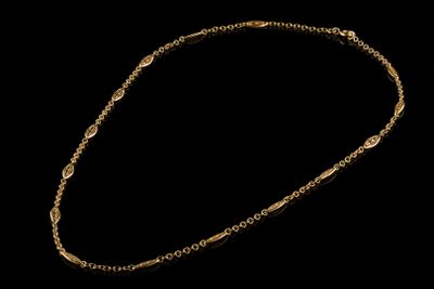 un collier en or dont la chaîne est mise en valeur sur un fond noir