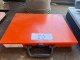 an orange box sitting on top of a table next to a pile of other items