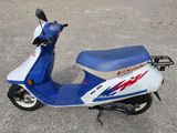 un scooter bleu et blanc garé sur un parking