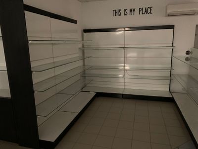 une photo d'un magasin aux rayons vides, avec une pancarte indiquant « C'est chez moi »