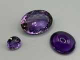 trois améthystes posées sur une table, dont une violette et une noire