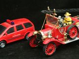 une petite voiture rouge et une autre petite voiture rouge sur fond noir