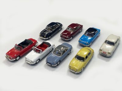 several toy cars are lined up in a row on a white surface
