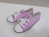 des Converse violettes et blanches avec des lacets blancs sur un fond blanc