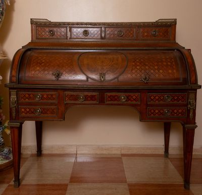 un bureau en bois avec des tiroirs et un vase posé dessus