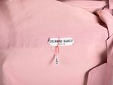 a close up of a pink shirt with a name tag on it