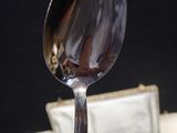 a spoon that is sitting on a plate with a piece of cake