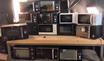 de nombreux micro-ondes et grille-pain empilés sur une table