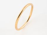 gros plan d'une bague en or sur fond blanc