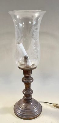 a glass vase with a cigarette in it sitting on a table