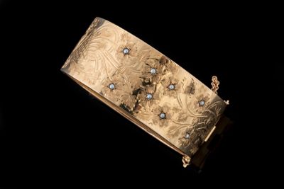 une image représentant un bracelet en or serti de diamants sur fond noir