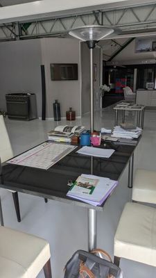 une table avec des chaises et une valise posée dessus, dans une pièce