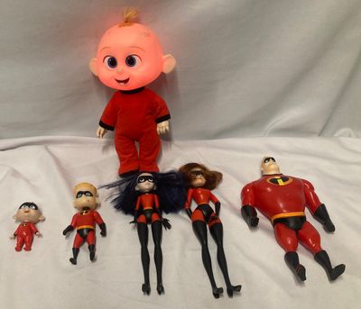 a group of dolls that are sitting on a white sheet