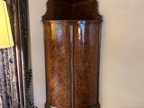 a tall wooden cabinet in the corner of a room