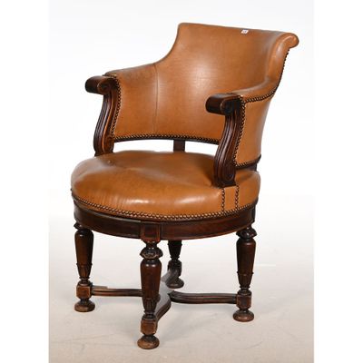 un fauteuil en cuir marron posé sur une table en bois