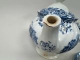 a blue and white vase with a bird on top of it