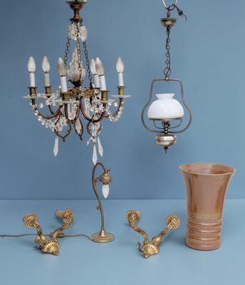 a chandelier that is next to a vase on a table