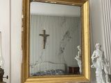 un miroir et une statue posés sur la cheminée d'une pièce