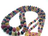 collier composé de perles multicolores et d'un pendentif doré sur fond blanc