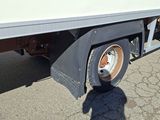 a white truck with a flat bed parked in a parking lot