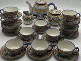 many cups and saucers and a teapot on the table