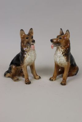 deux figurines de chiens assis l'une à côté de l'autre
