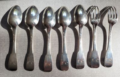 six cuillères et une fourchette posées sur une table