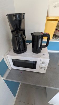 un micro-ondes et une cafetière posés sur le micro-ondes