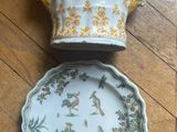 two plates and a bowl sitting on a wooden floor