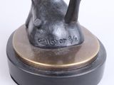 bronze statue of a giraffe on a black base with a white background