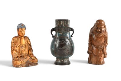 trois petites statues de bouddhas assis les uns à côté des autres sur une surface blanche