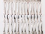 a lot of forks and spoons on a white surface